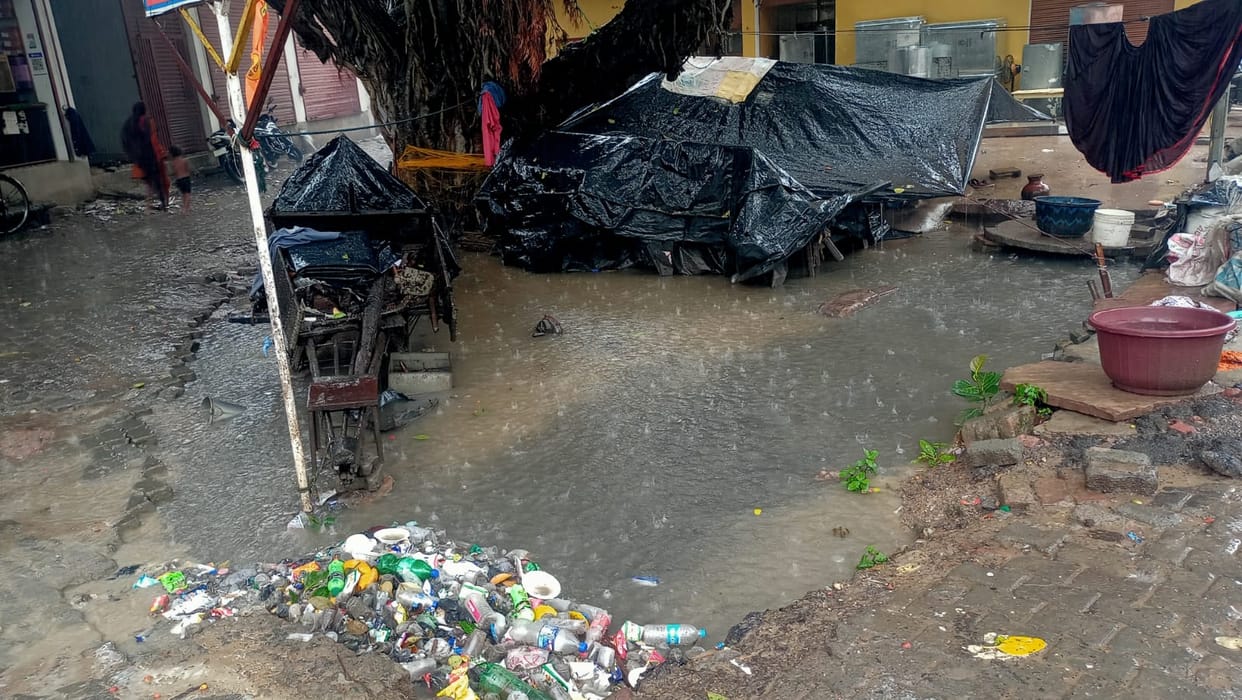 The family's hut, built by the side of the drain, is surrounded by water.