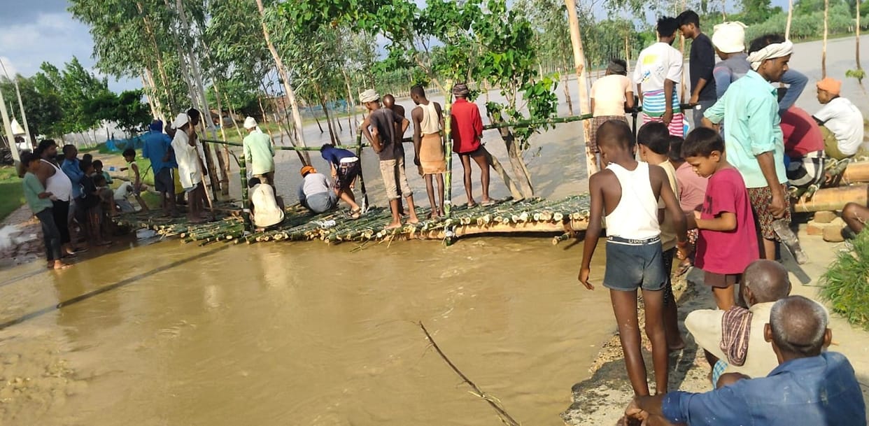 Road washed away by floods; villagers built a wooden bridge through voluntary labor