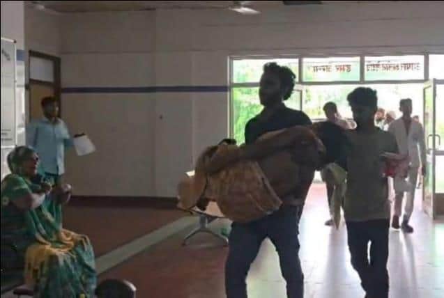 Son carries mother in his arms to the emergency ward after failing to get a stretcher.
