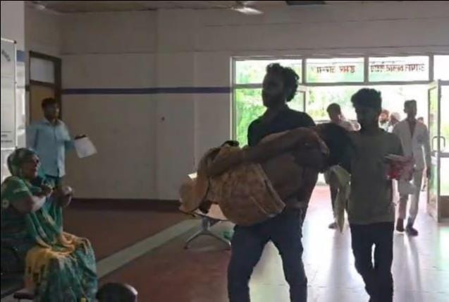 Son carries mother in his arms to the emergency ward after failing to get a stretcher.