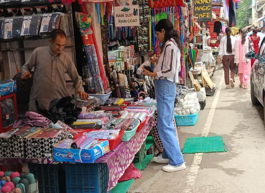 हमीरपुर बाजार में फोल्डिंग छाते की खरीदारी करते हुए युवती। संवाद