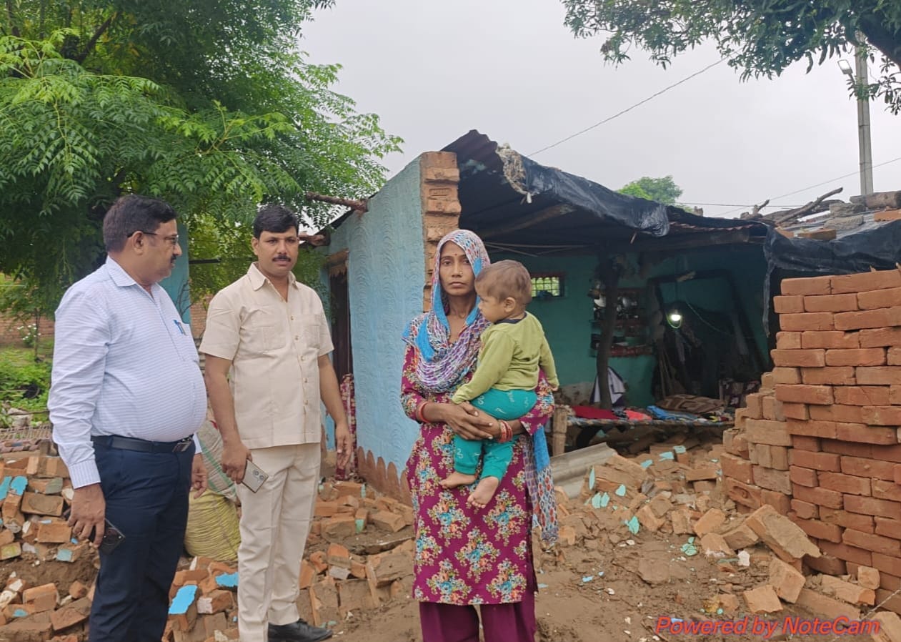 मंडावर के गांव मिर्ज़ापुर खादर में मकान की दीवार गिरने के बाद पीड़िता से जानकारी लेते खंड विकास अ