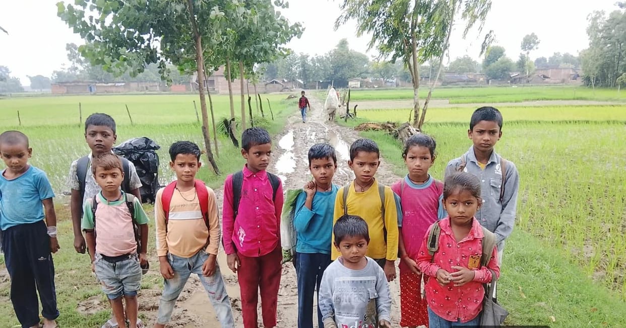 Children walk through mud to get to school.