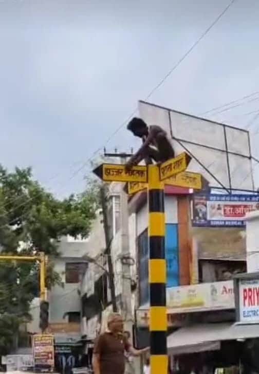 Cleaner climbed a pole; brought down after a 20-minute struggle.
