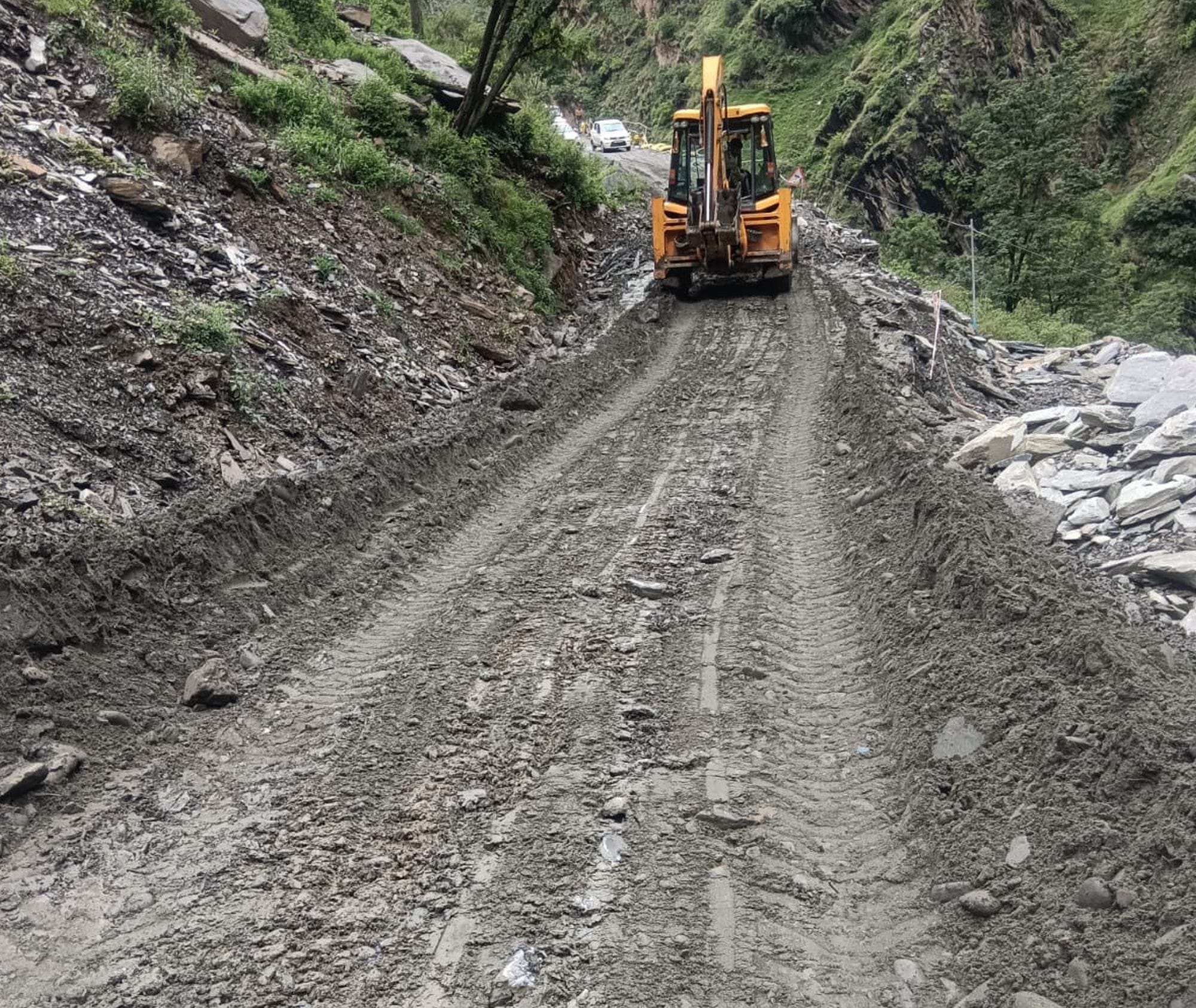 चंबा में बारिश के बाद बंद पड़े भरमौर एनएच को बहाल करने में जुटी जेसीबी मशीन।संवाद