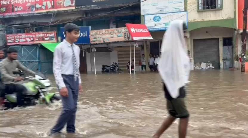 फोटो-42-मुख्य मार्ग पर हुआ जलभराव से होकर निकलते लोग। संवाद
