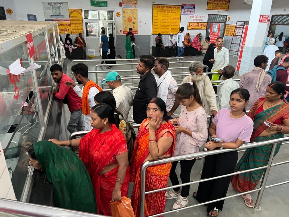 जिला अस्पताल स्थित ओपीडी में रजिस्ट्रेशन काउंटर के कतार में खड़े बड़े और बच्चे।संवाद