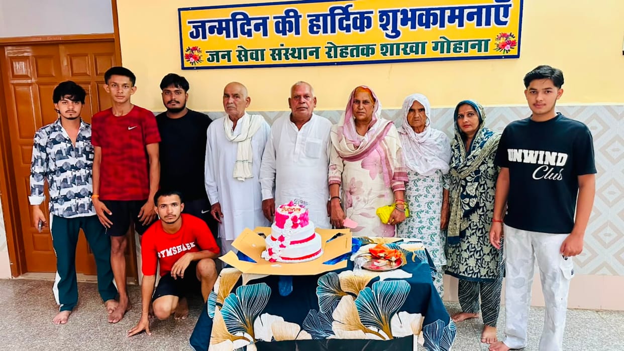 Grandparents cut a cake at the ashram on their grandson's birthday.