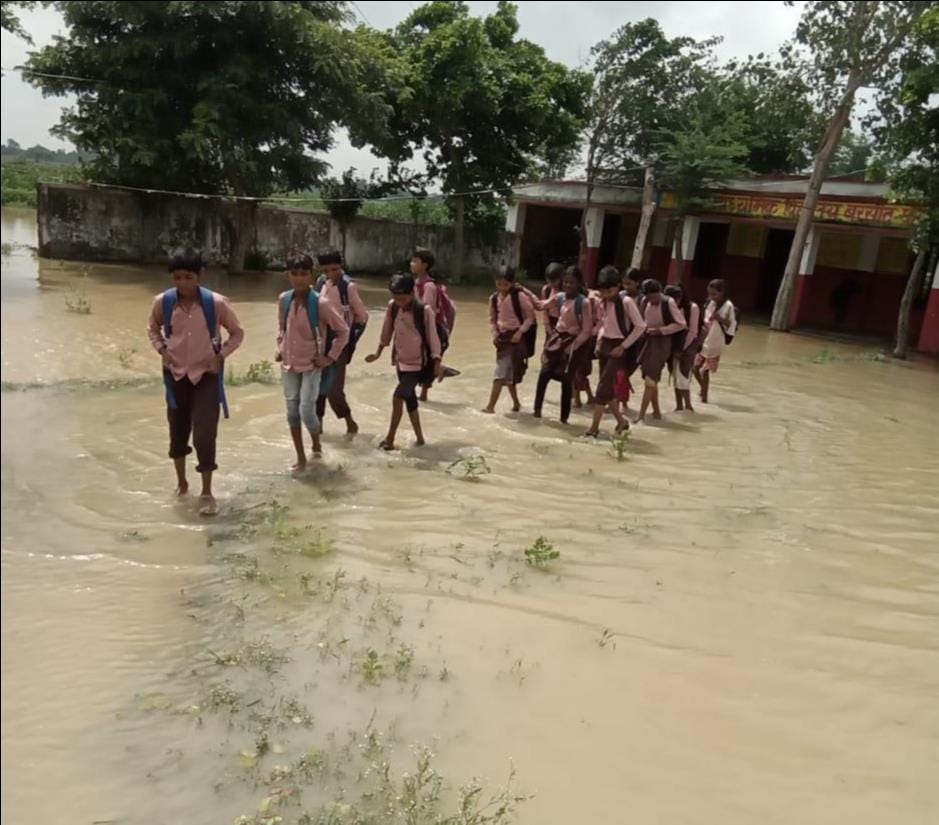 Children are forced to go to school through water.
