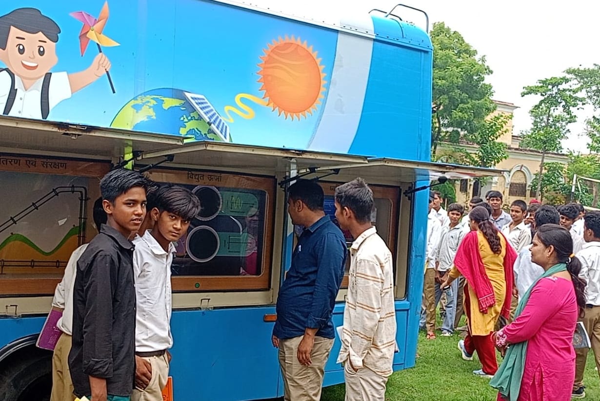 वैन में गतिविधियां देखते छात्र।