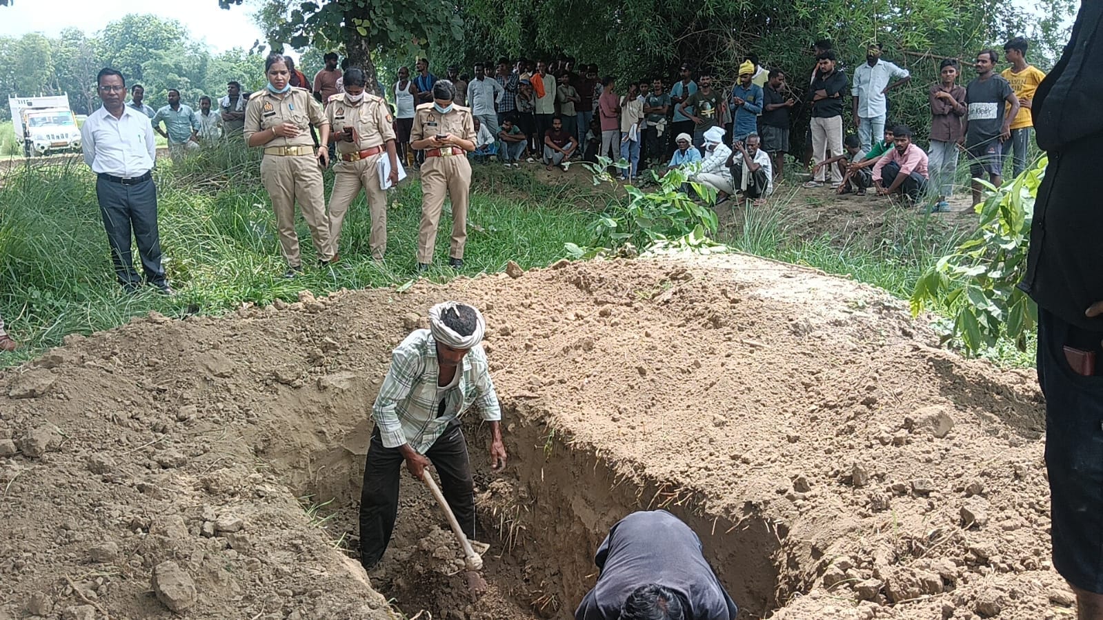अकबरपुर के रामपुर बनेथू गांव में महिला सीता देवी का शव निकालने के लिए खोदी जा रही कब्र। संवाद