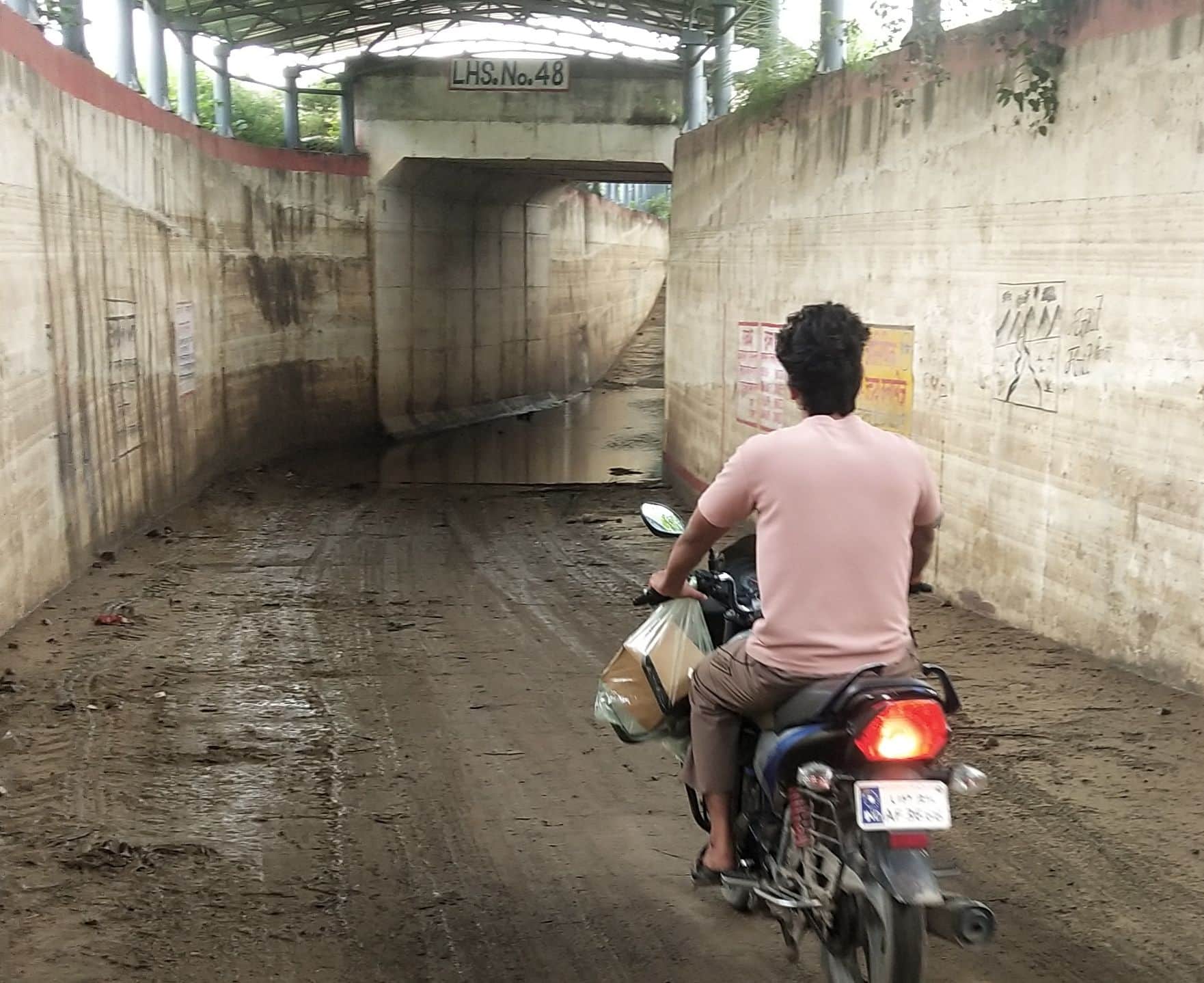 फोटो- 31-ताजपुर के रेलवे अंडर पास से निकलता बाइक सवार। संवाद