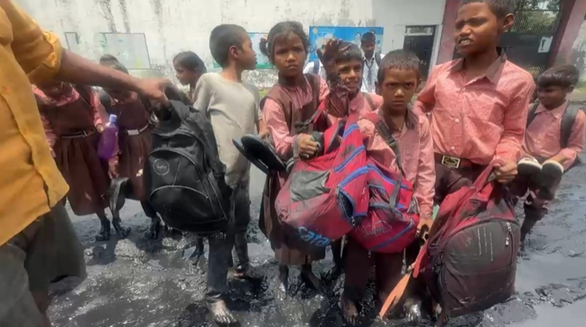 फतेहउल्लापुर गांव के प्राथमिक विद्यालय में जमे कीचड़ के बीच खड़े बच्चें। स्रोत- आयोजक