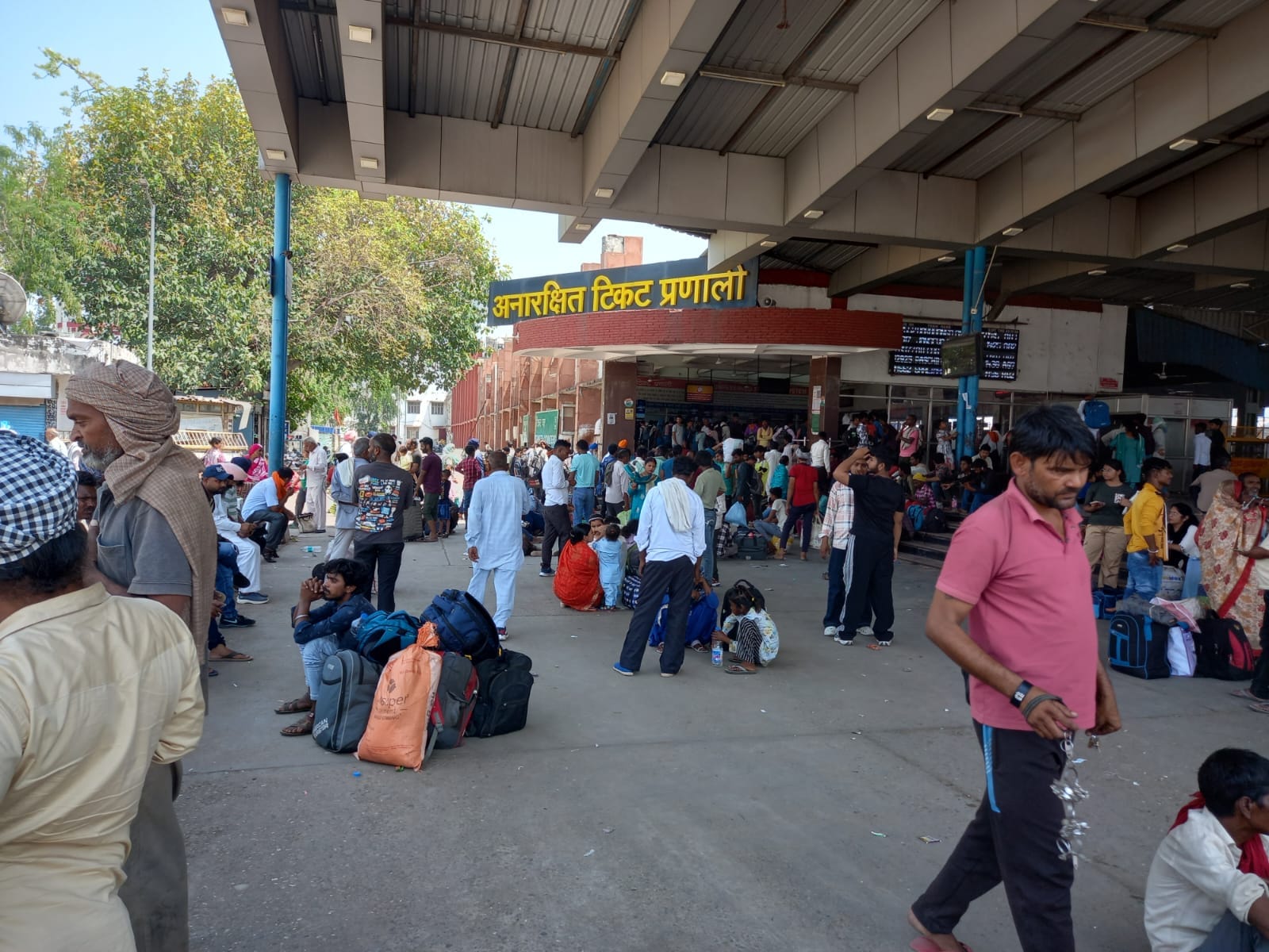अंबाला कैंट रेलवे स्टेशन के अनारक्षित केंद्र पर सामान लेकर बैठे यात्री। संवाद