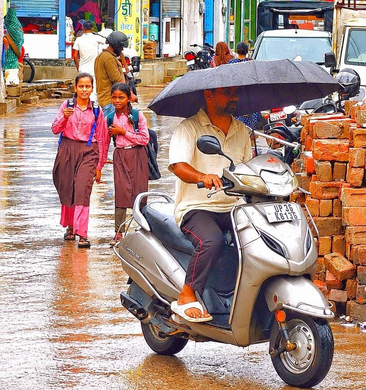 अमेठी में बारिश के दौरान सड़क से गुजरते लोग।-संवाद