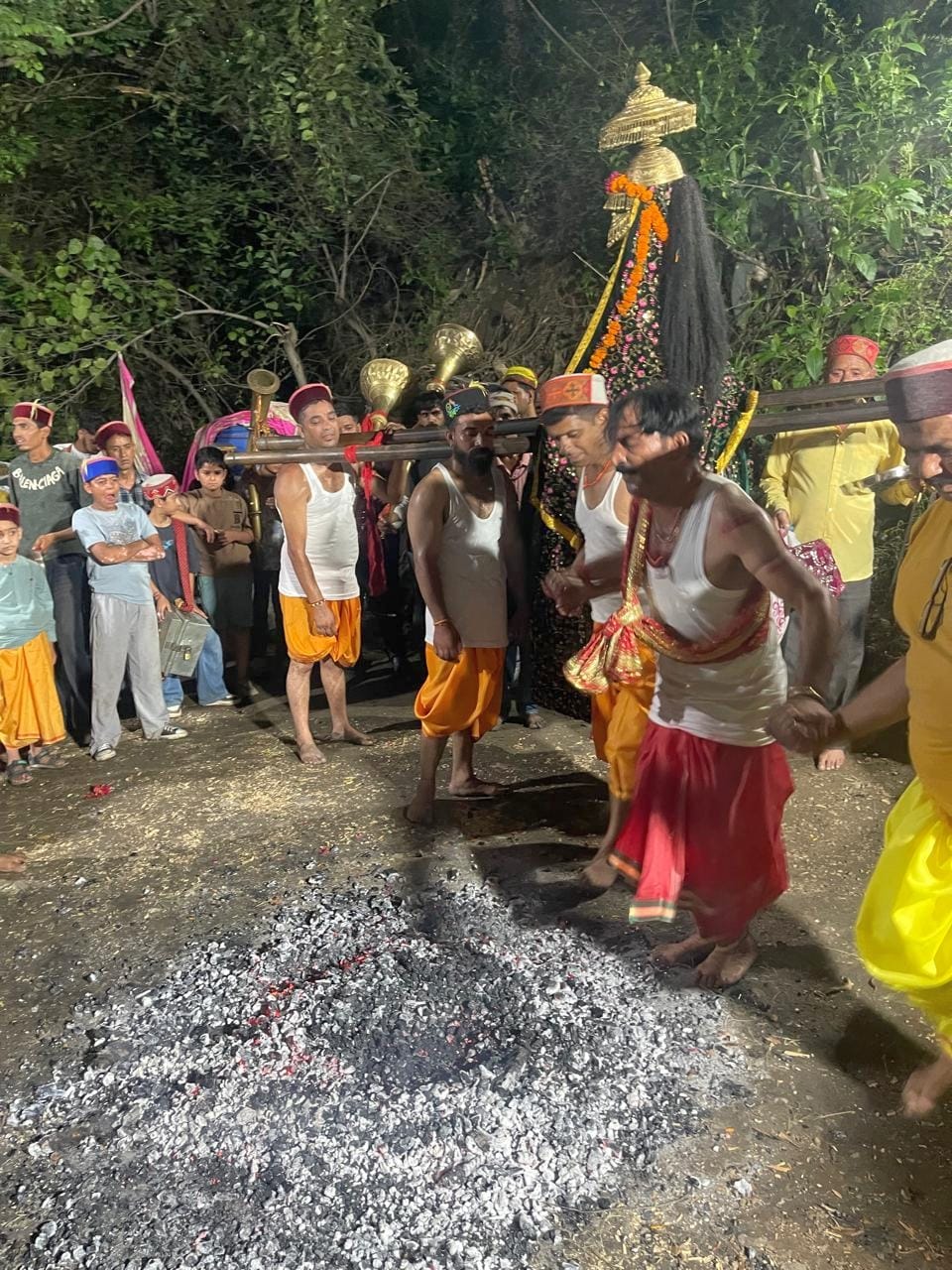 भुंतर के अंबेडकर नगर में मां नैना माता के वार्षिक जाग उत्सव के दौरान अगांरो पर नृत्य करते देवलू