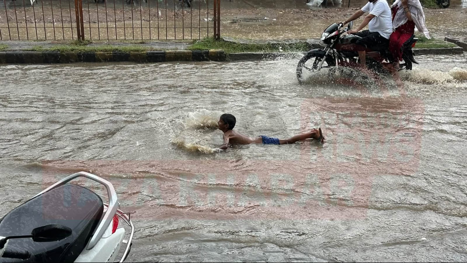 बारिश के बाद सड़क पर खड़े पानी में मस्ती करते बच्चे :संवाद