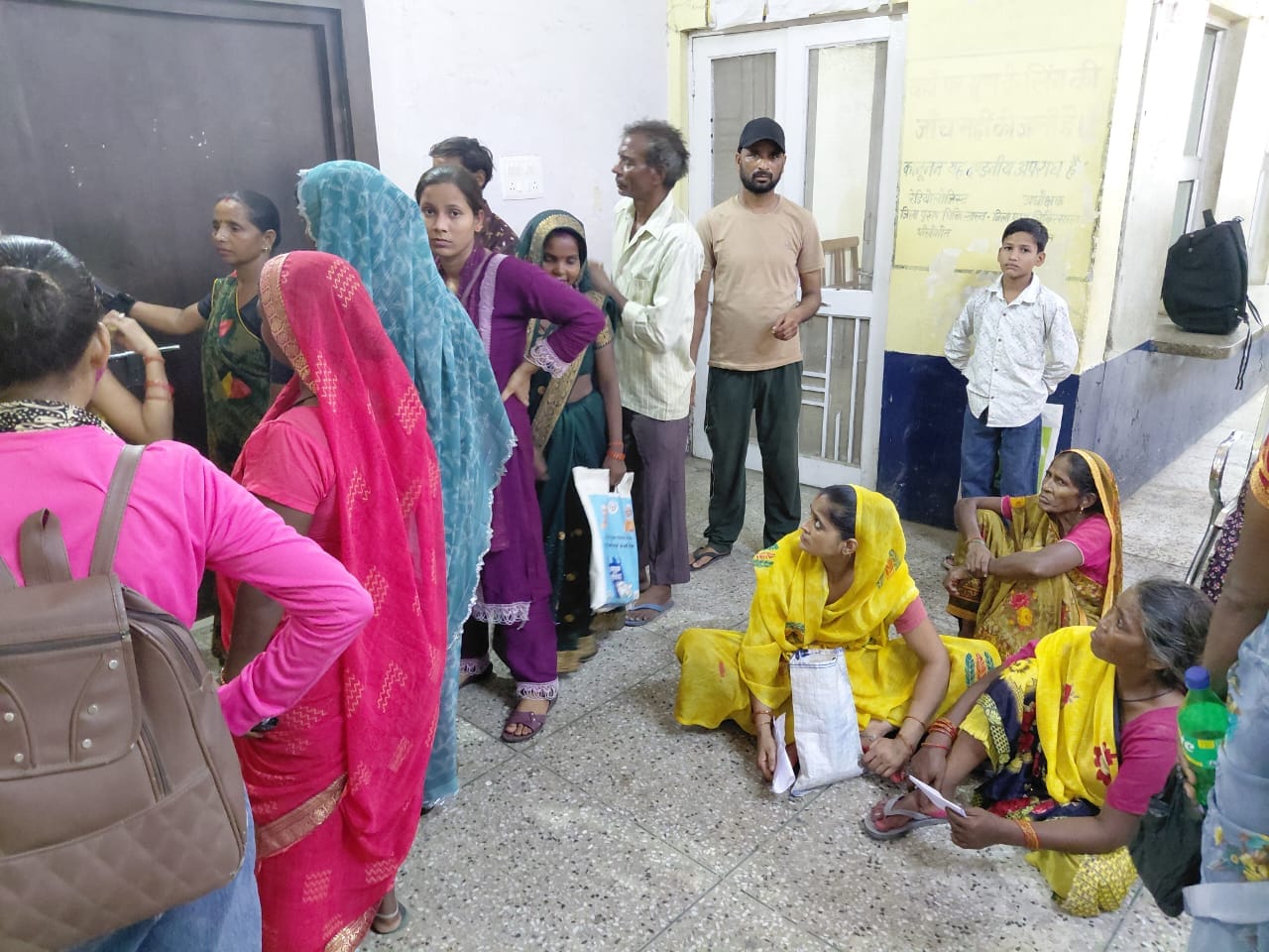 एक्सरे के लिए कक्ष के लिए जमीन पर बैठीं महिलाएं। संवाद