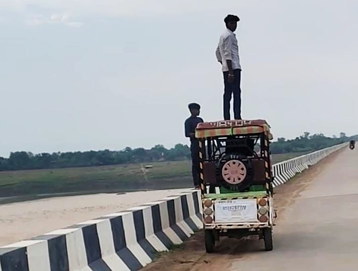 Stunt performers gather on the Yamuna Bridge as evening falls.