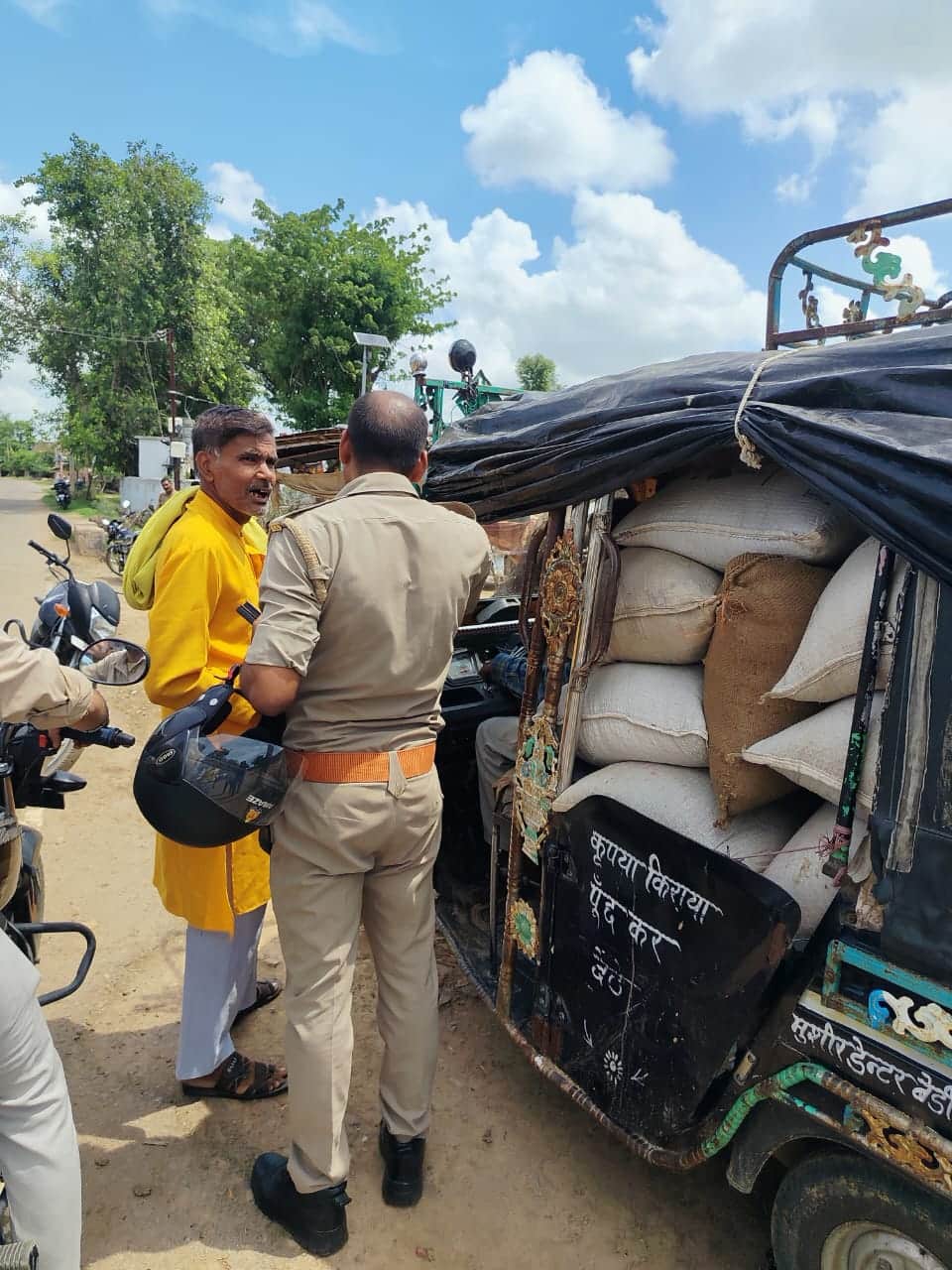 फोटो -7- सरकारी राशन से लदा टेंपो व मौजूद पुलिस कर्मी। संवाद