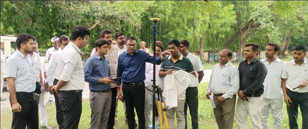 District Magistrate inspects land measurement using rover technology.