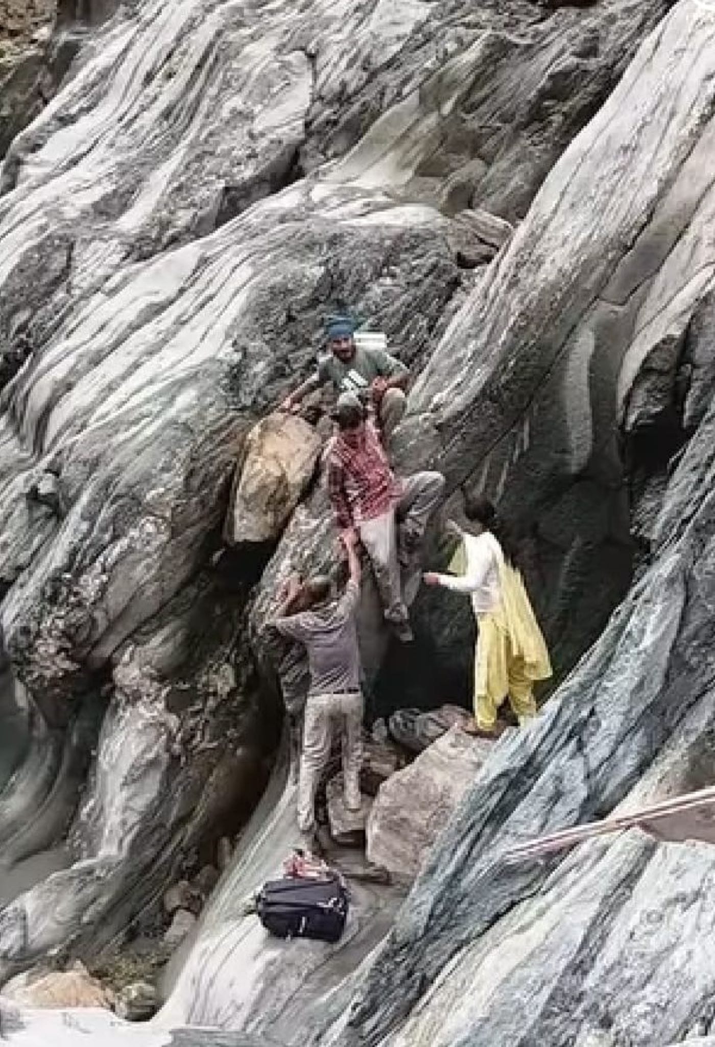 ढलानदार चट्टान से नीचे उतरतेधिमला पंचायत के कलेला गांव  केग्रामीण। संवाद