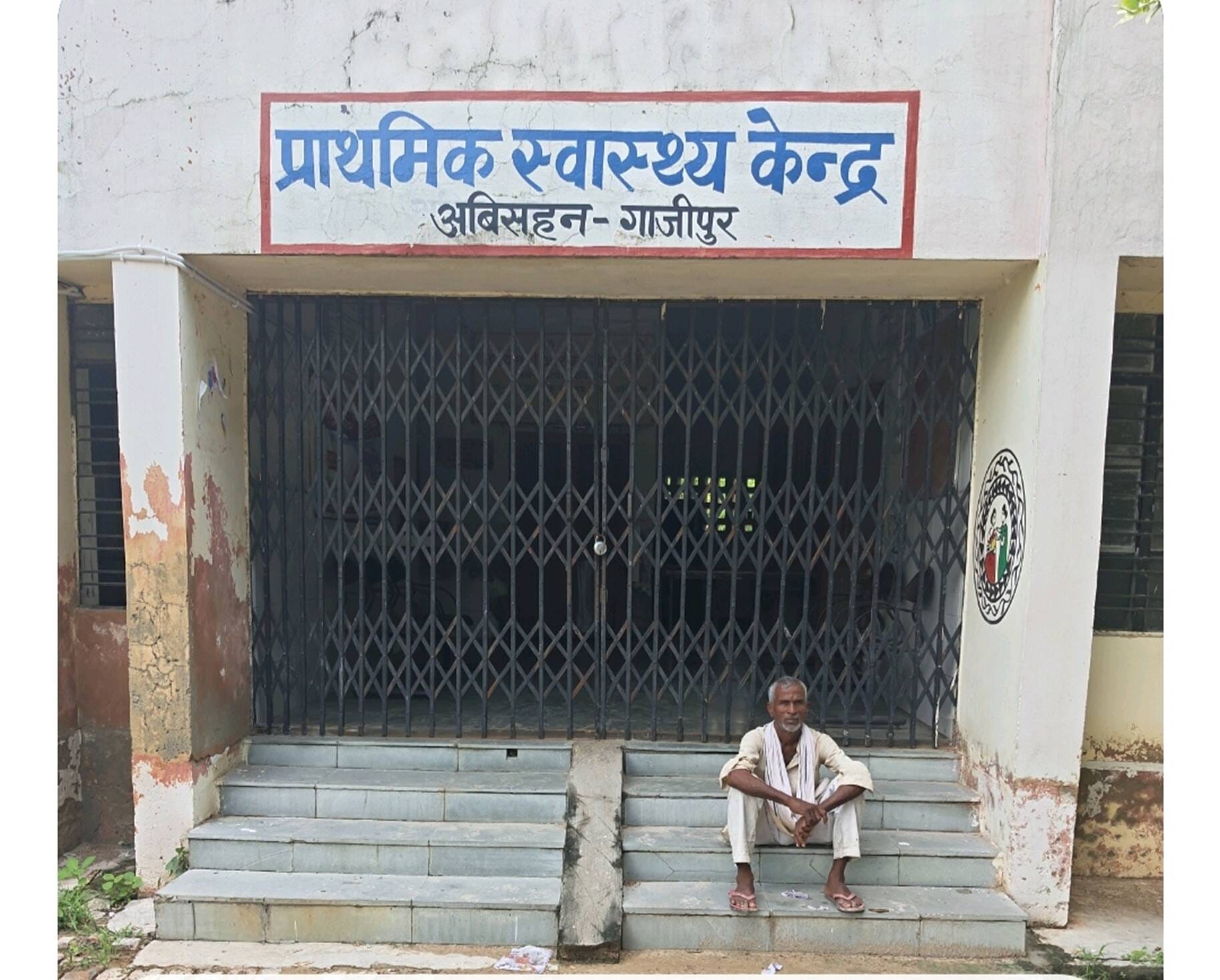 प्राथमिक स्वास्थ्य केंद्र उबिसहन का गेट बंद रहने पर सिढि़यों पर बैठा मरीज। संवाद