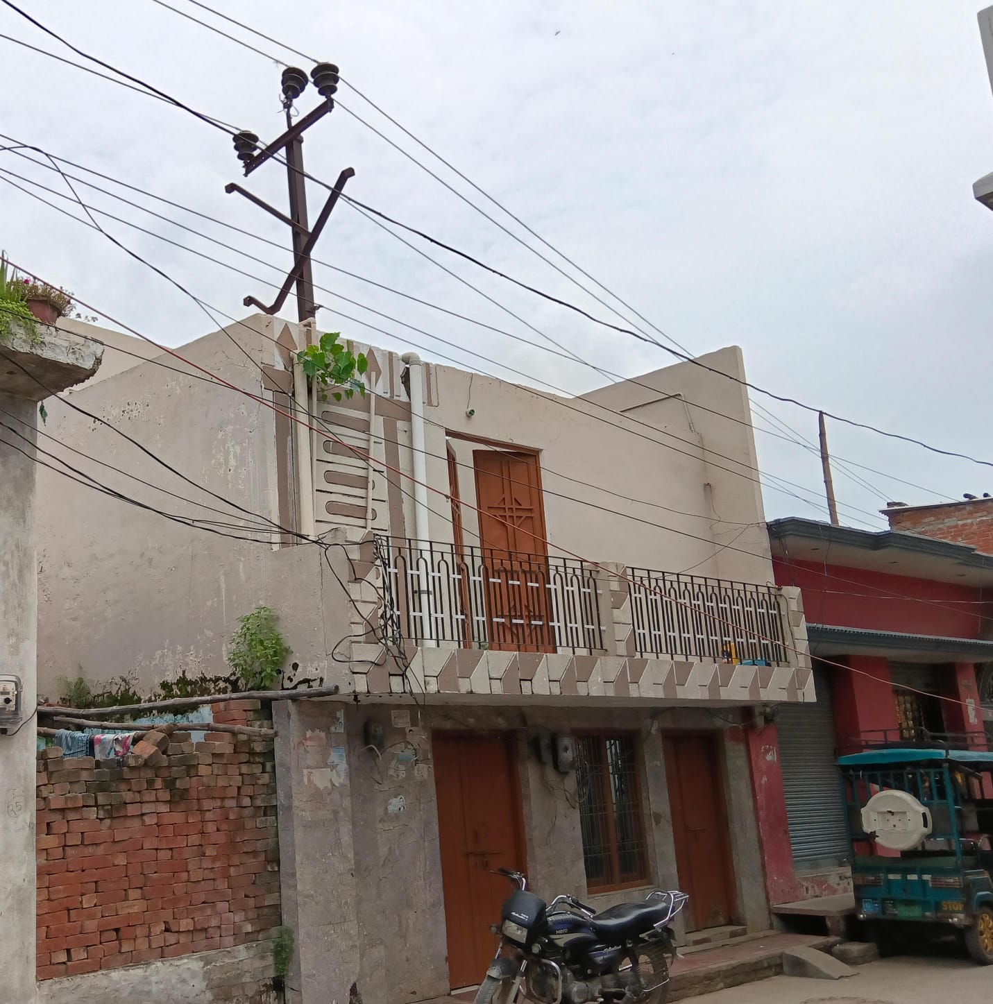 शहर से सटी नगर पंचायत  नौगवां पकड़िया में घर के अंदर लगा बिजली का खंभा। संवाद