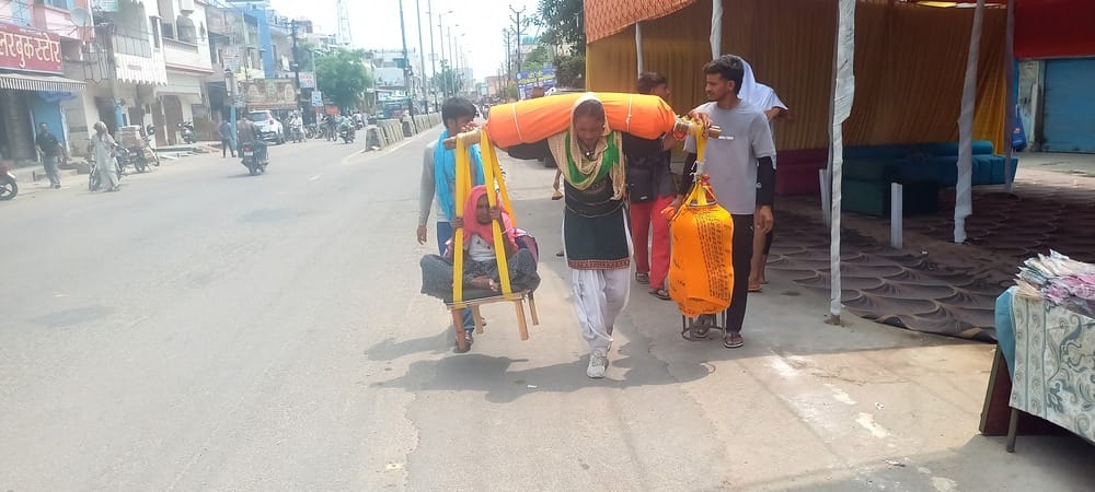1 पुरकाजी से अपनी सास को कावड़ में बैठाकर गुजरती महिला कावड़िया। संवाद