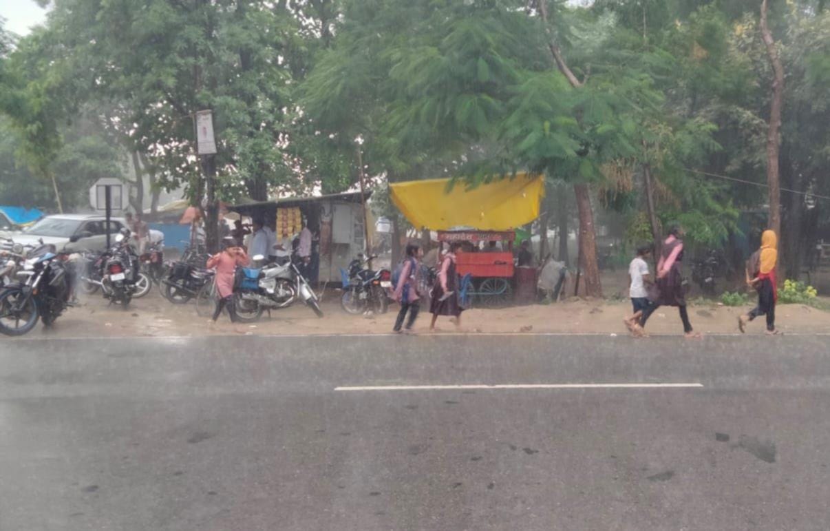 भिनगा में बारिश के दौरान भीगकर जाते विद्यार्थी।