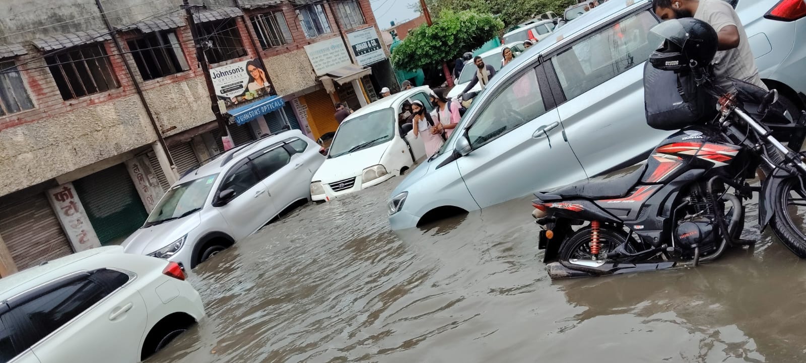 डीएम रोड पर बारिश के पानी में फंसे वाहन। संवाद