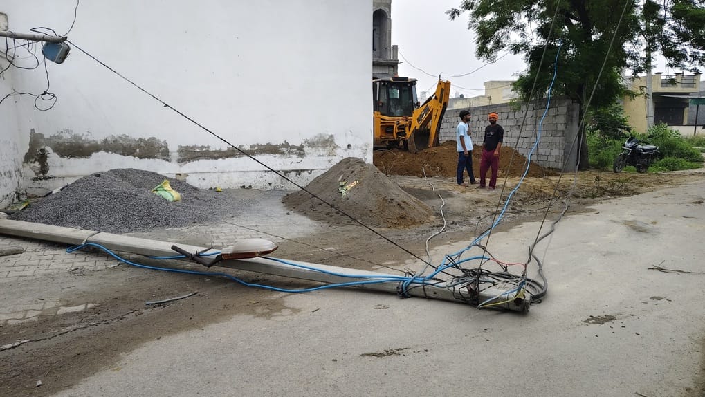 A bulldozer hit an electric pole and it fell on the road, a major accident was averted.