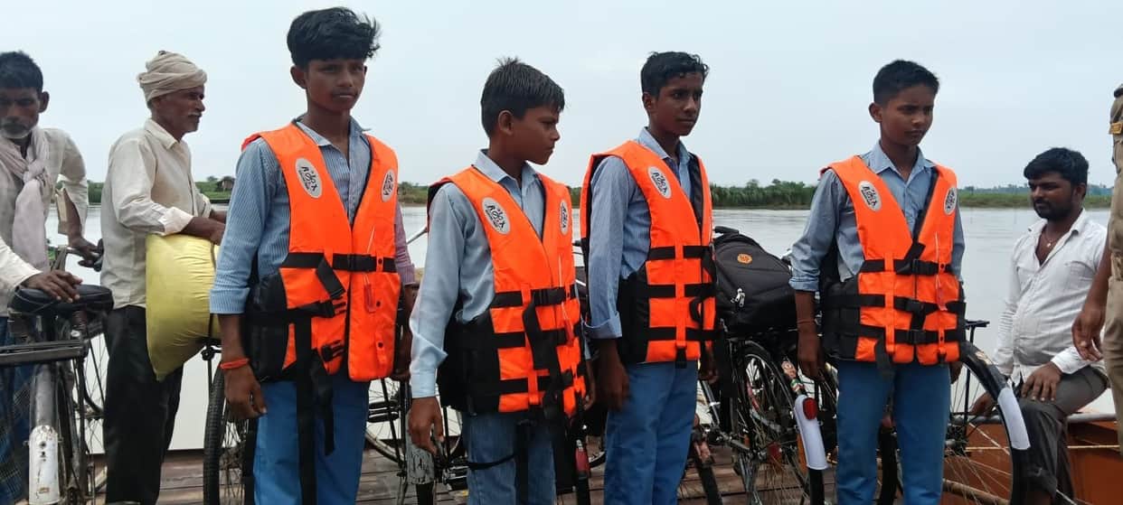 Crossing the Saryu in life jackets to reach school.