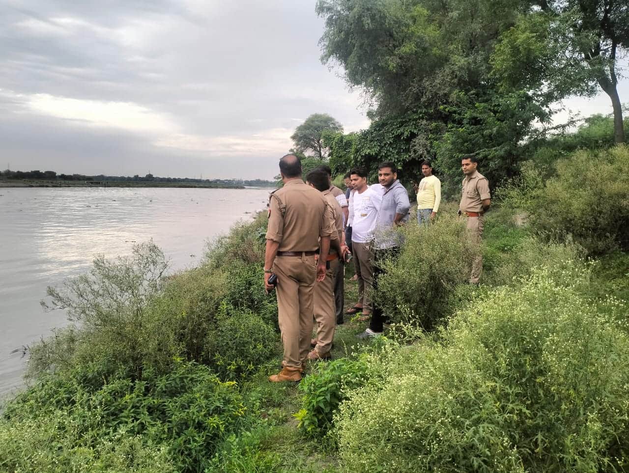 बच्चे का शव निकालने के दौरान घाट पर मौजूद पुलिसकर्मी व अन्य। 