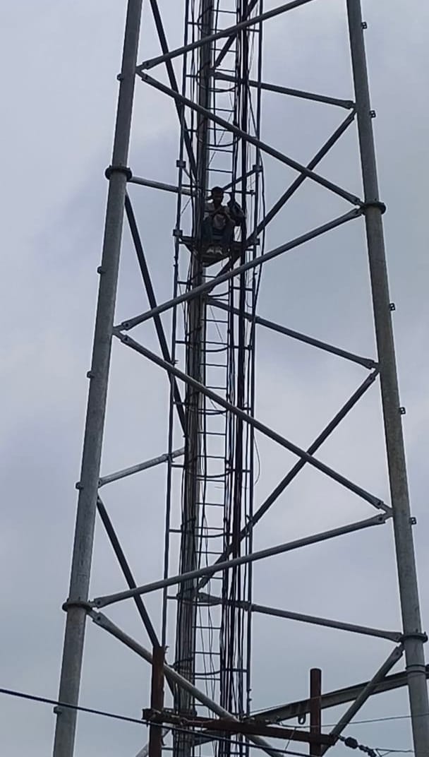 Youth climbed a tower to protest encroachment on a pond; came down after 12 hours