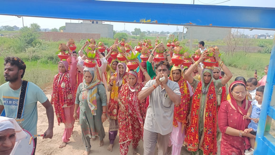 सिर पर कलश लेकर चलती महिलाएं। संवाद