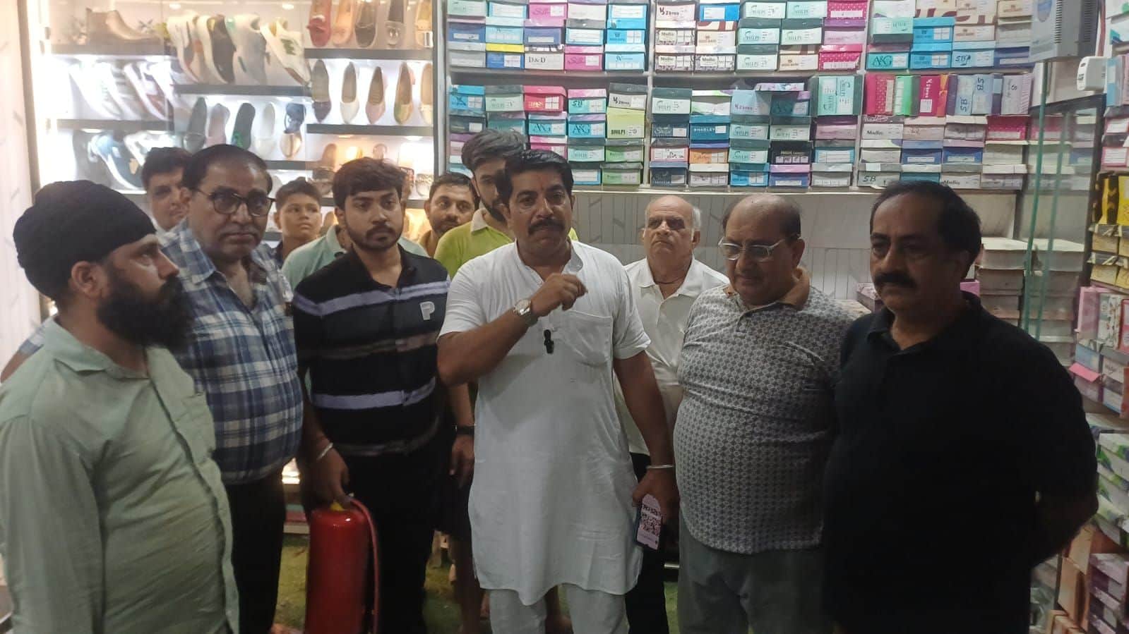 22-गांधी कैंप बाजार में जूतों की दुकान में आग बुझाने के बाद चर्चा करते दुकानदार। स्रोत : दुकानद
