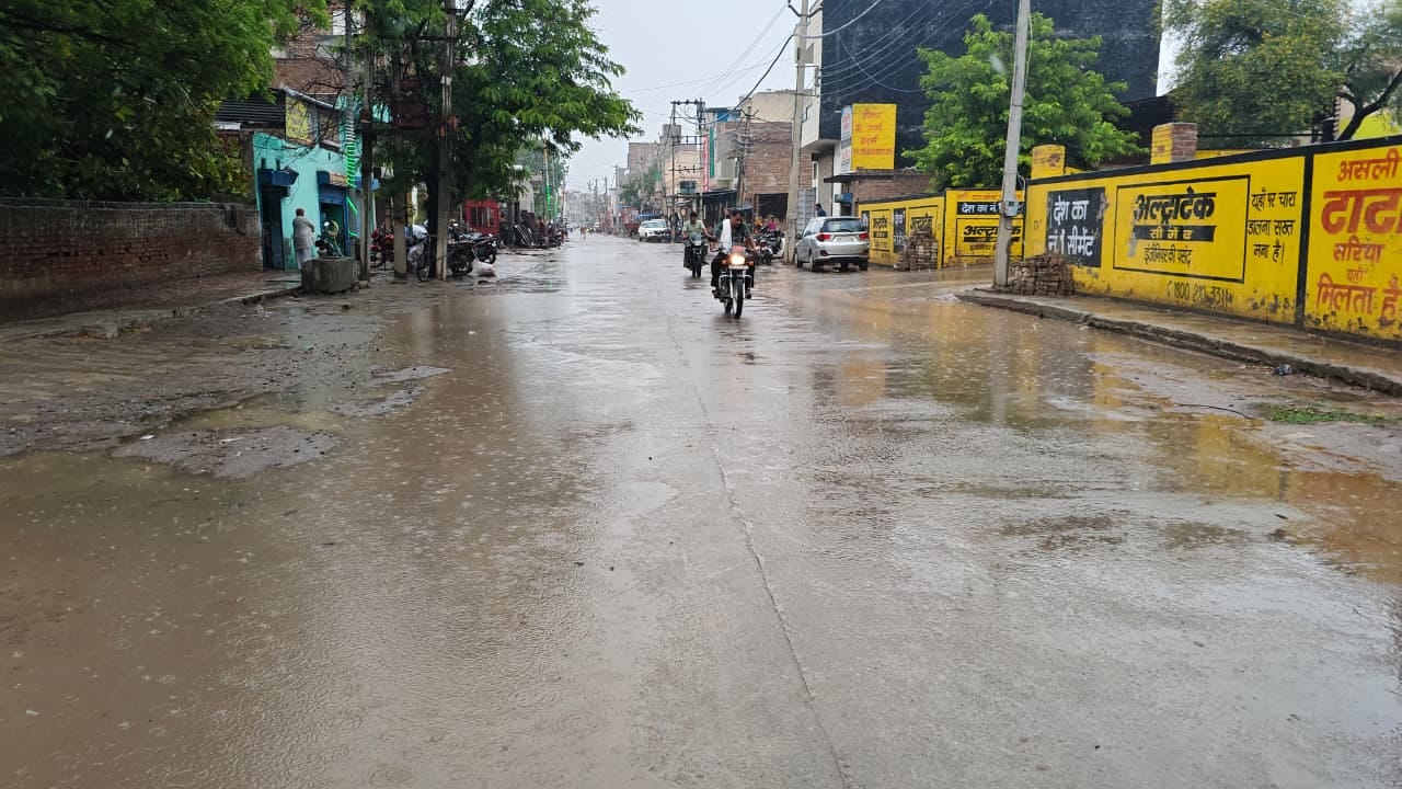 बारिश के दौरान आमटी झील के समीप से गुजरते वाहन। संवाद