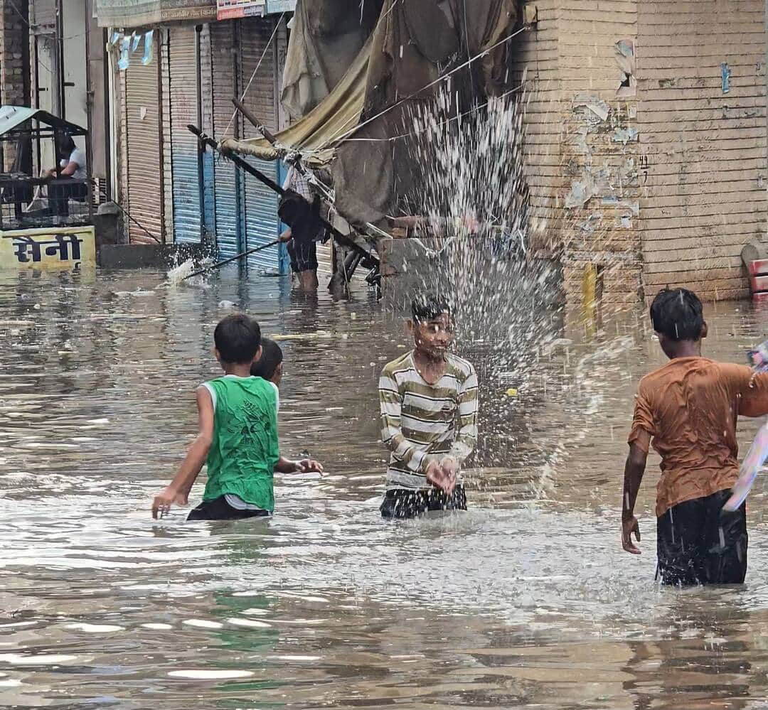 फोटो 11 नरवाना। शहर में गलियों में जमा बारिश के पानी में खेलते हुए बच्चे। संवाद।
