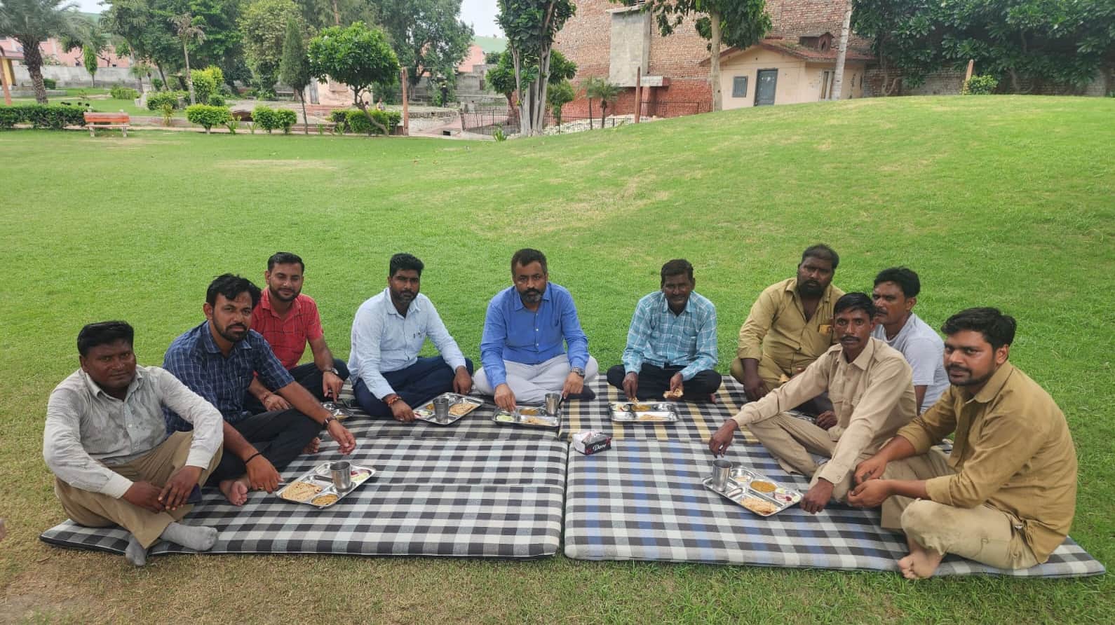 सफाई कर्मियों के साथ खाना खाते एसडीएम मनीष यादव। विज्ञप्ति