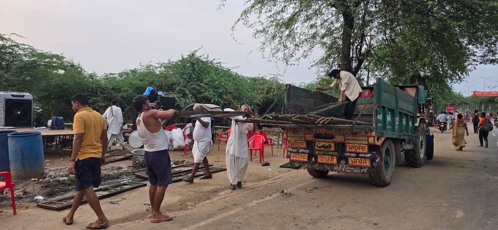 टेंट उखाड़ कर सामान ले जाते सेवाभाभी। 
