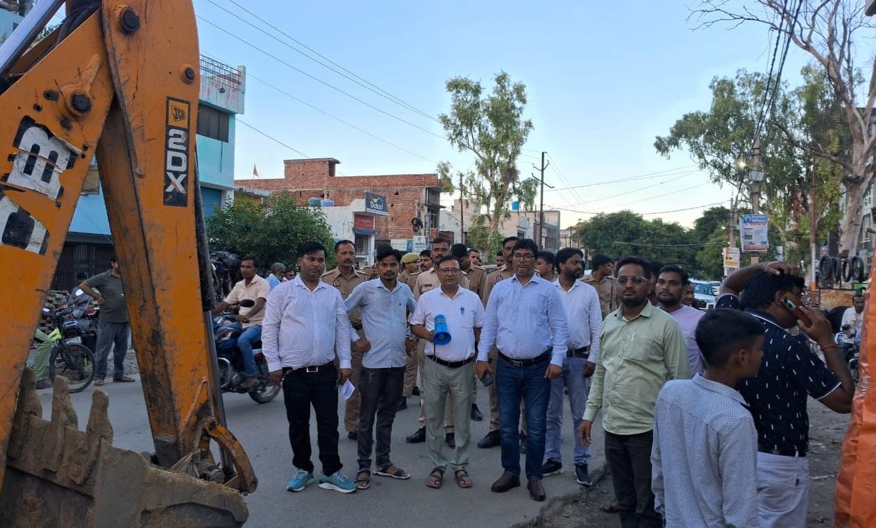उझानी में अतिक्रमण हटवाते पालिका और पुलिस कर्मी। संवाद