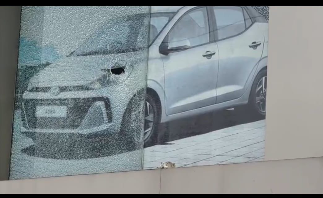 Car dealership pelted with stones in the dead of night; gate glass shattered.