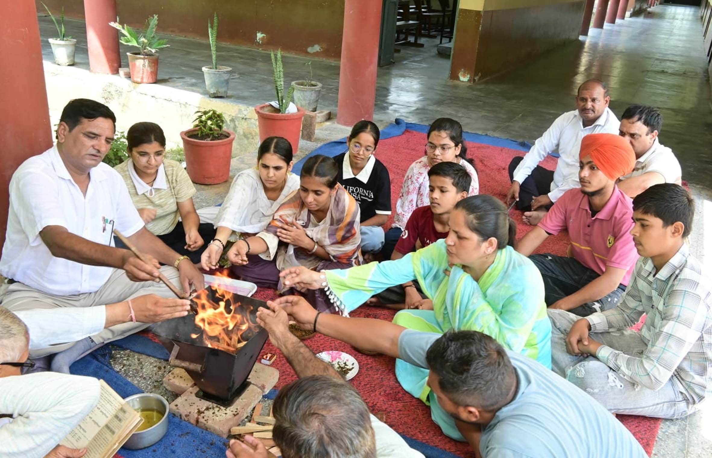 हवन में आहुतियां डालते विद्यार्थी व शिक्षक। संस्थान