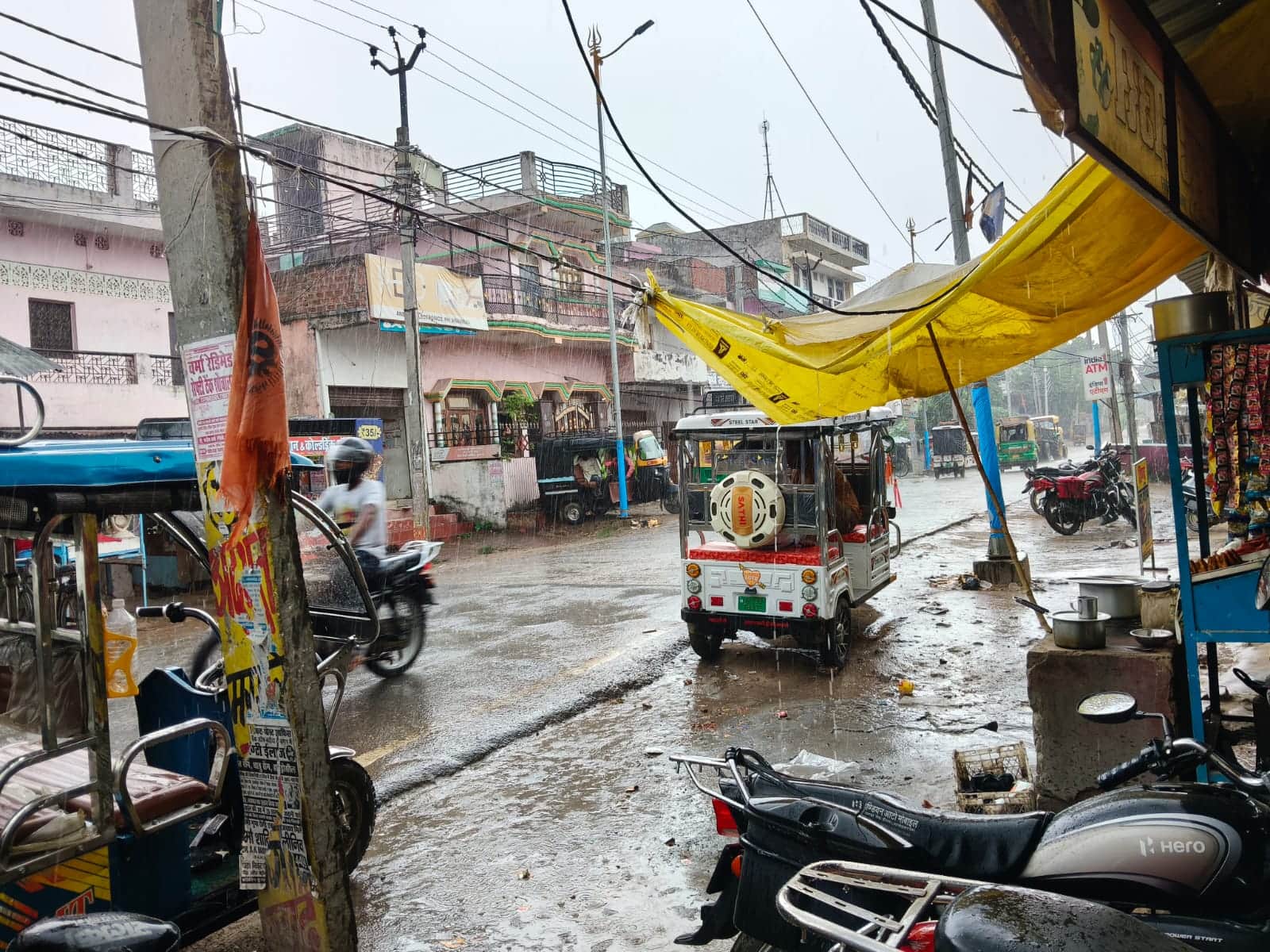 बसखारी बाजार में रविवार सुबह बारिश के बीच आवागमन करते वाहन चालक।संवाद