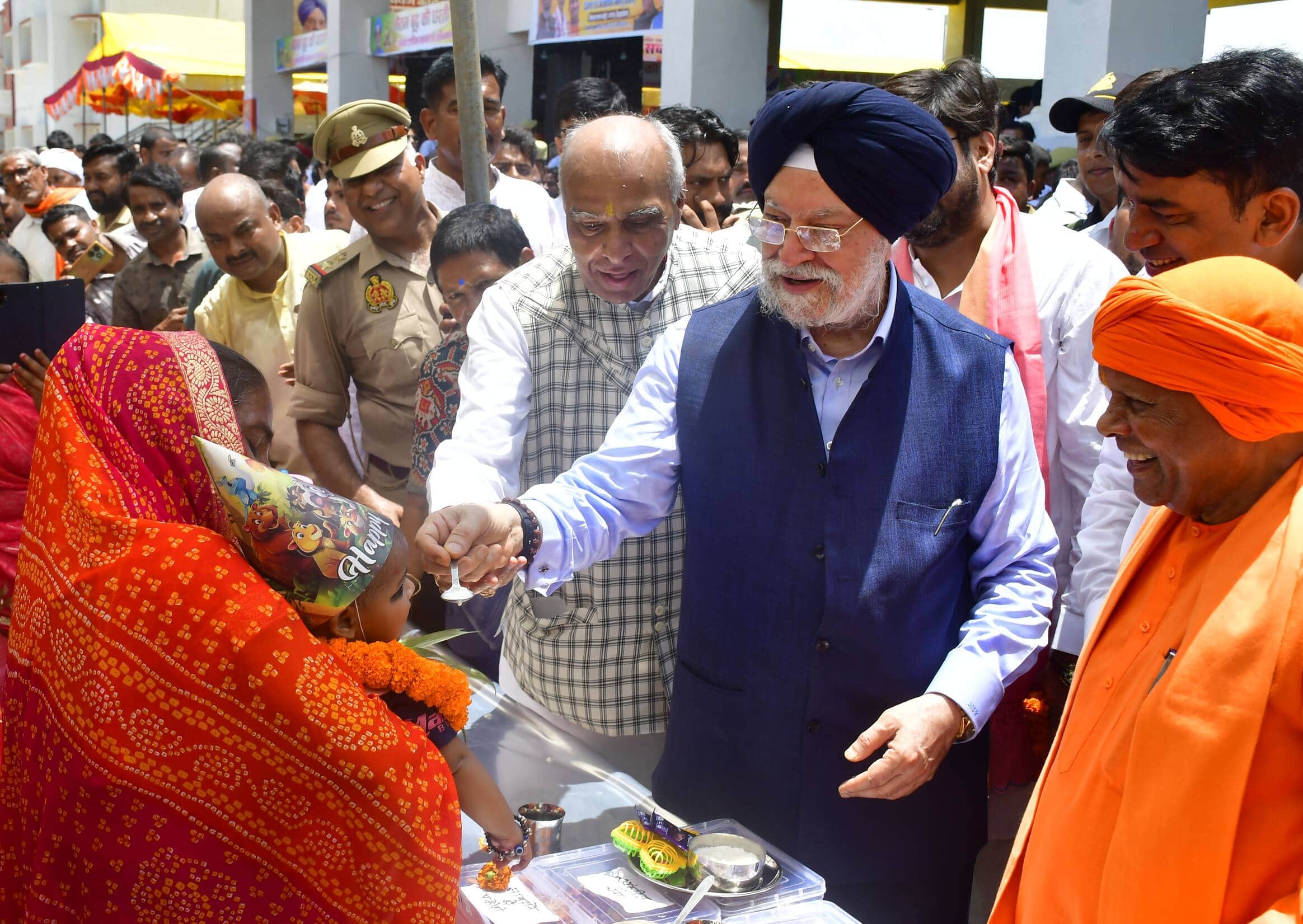 कपिलवस्तु के पिपरहवा में आयोजित लोकार्पण कार्यक्रम में बच्चों का अन्नप्रासन करते पेट्रोलियम एवं