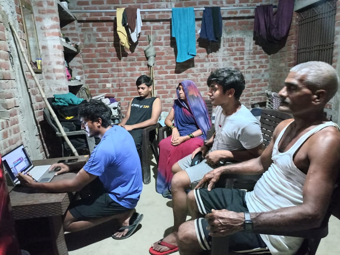 लैपटाप पर खेल का लाइव देखते रोहित यादव के परिवार के लोग। स्वयं