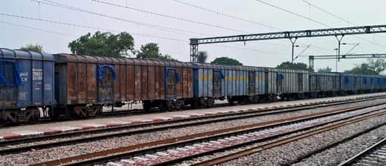 Freight train arriving for loading; maize-laden trucks waiting at markets; delay will incur a penalty.