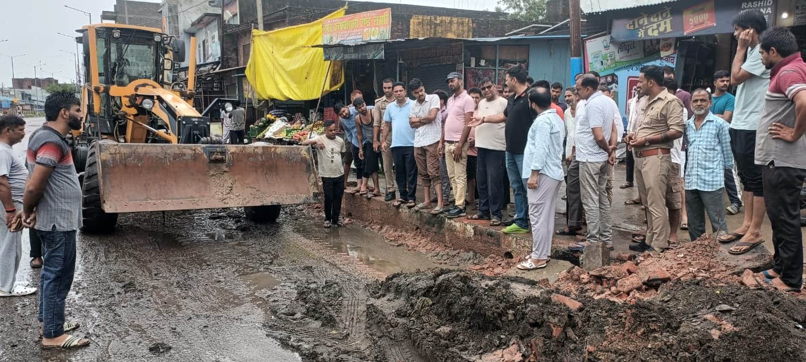 अमरिया कस्बे में सड़क किनारे सफाई करती जेसीबी मशीन मौके पर मौजूद व्यापारी संवाद