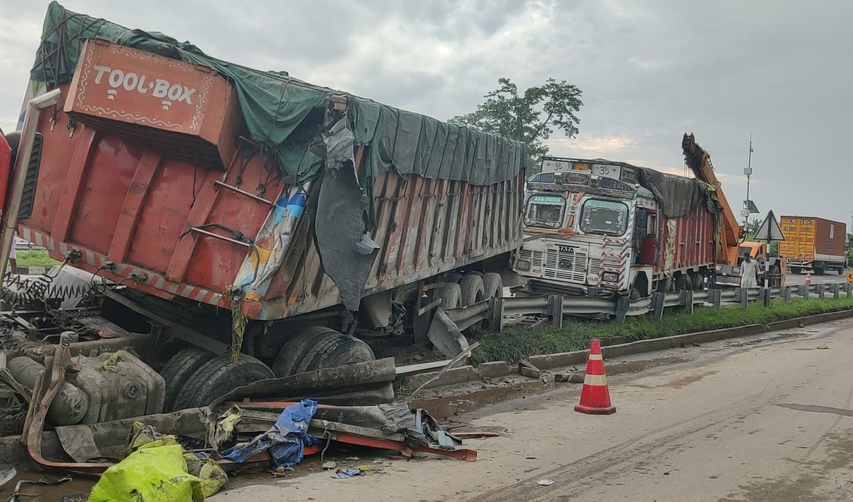 Container truck crashes into stationary truck while trying to avoid a car; gets stuck in a drain